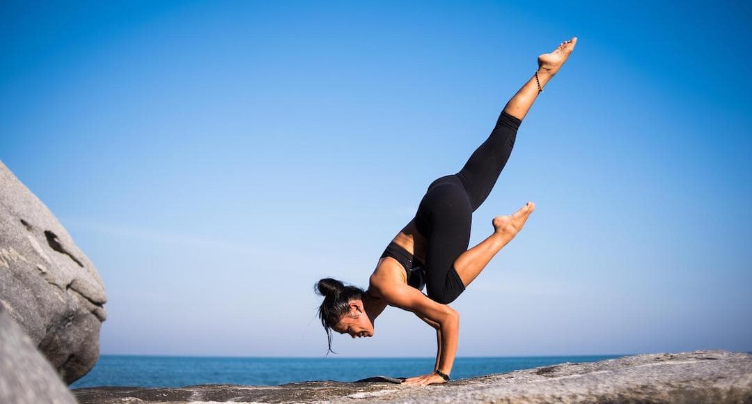 Person balancing in a yoga pose to illustrate the need to strike a balance in your investment portfolio.