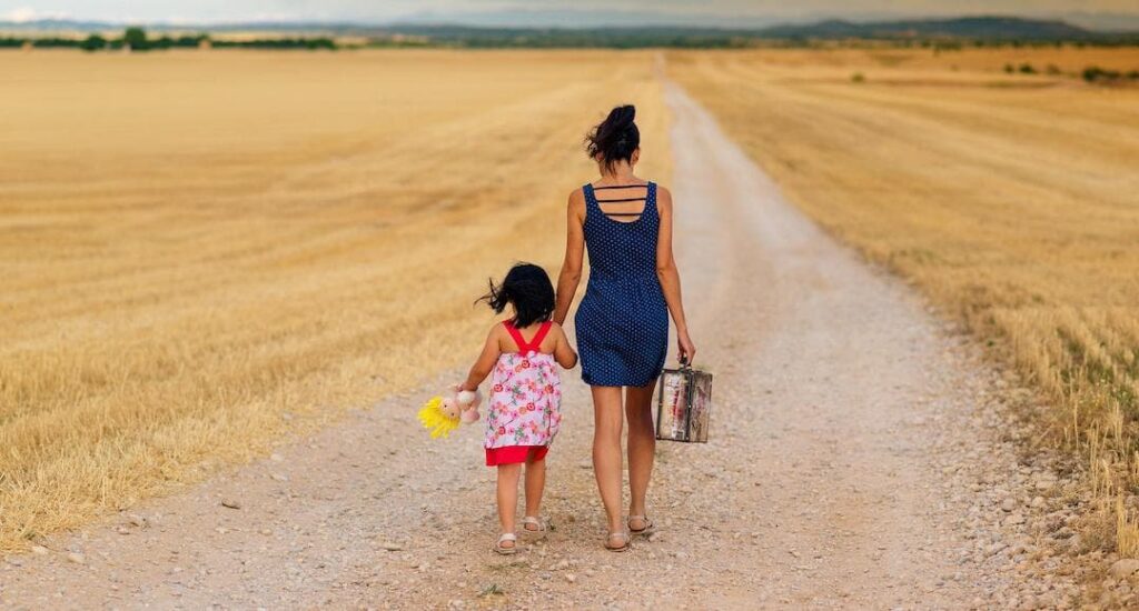 Parent and child walking on a dirt road to illustrate family history.