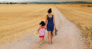 Parent and child walking on a dirt road to illustrate family history.